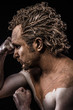 man covered in mud and naked