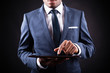 Photo: Businessman working on a digital tablet against black backgroun Businessman working on a digital tablet against black backgroun