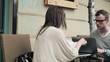 Young students working with laptop computer in cafe