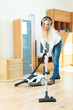   woman in headphones cleaning with vacuum  cleaner