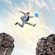 Businessman jumping over gap