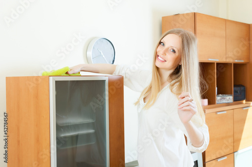Photo: Happy long-haired housewife cleaning furniture Happy long-haired housewife cleaning furniture