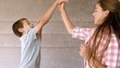 Siblings high-fiving in bedroom