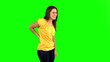 Woman rubbing painful back on green screen
