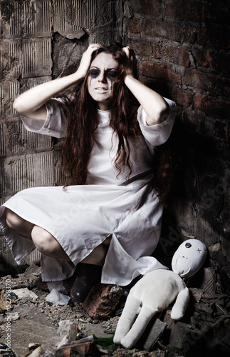 Photo: Horror style shot: strange crazy girl and her moppet doll Horror style shot: strange crazy girl and her moppet doll