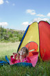 Little girl lying on the mat near colorful tent