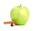 Ripe green apple with cinnamon sticks