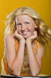 Beautiful blond girl with freckles sitting on a chair and smilin
