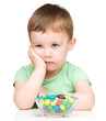Portrait of a sad little boy with candies