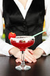 Barmen hand with shaker  pouring cocktail into glass,