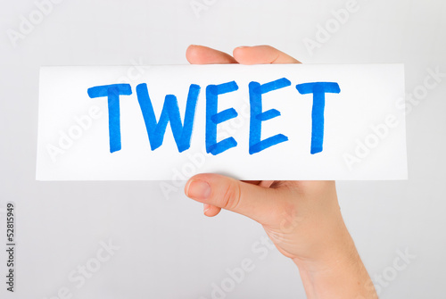 Photo: Hand showing tweet word Hand showing tweet word