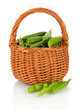 Sweet green peas in wicker basket isolated on white