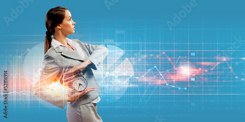Photo: Business woman holding alarmclock Business woman holding alarmclock