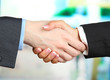 Photo: Business handshake on bright background Business handshake on bright background