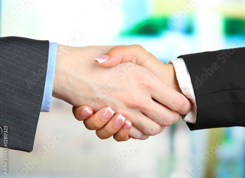 Photo: Business handshake on bright background Business handshake on bright background