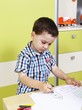 Little boy drawing with crayons