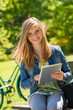 Teenage girl holding digital tablet in park