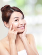 Beauty young woman applying cosmetic cream