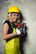 Attractive builder woman with a drill in her hands