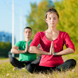 Man and woman woman doing yoga in park