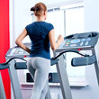 Young woman at the gym run on on a machine