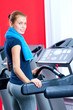 Young woman at the gym run on on a machine