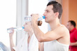 Man and woman drinking water after sports in gym