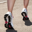 Woman legs in sneakers on asphalt