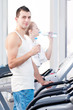 Man and woman drinking water after sports in gym