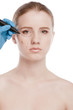 Beautician draw correction lines on woman face