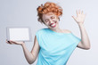 Emotional red-haired girl holding a tablet computer