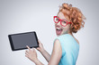 Emotional red-haired girl holding  tablet computer.
