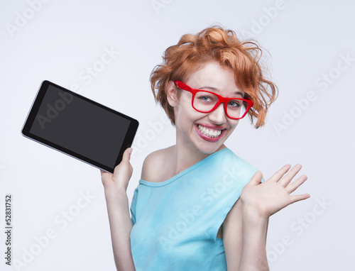 Photo: Emotional red-haired girl holding tablet computer Emotional red-haired girl holding tablet computer