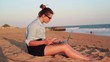 Businesswoman working with smartphone and laptop on the beach