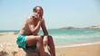 Young happy man talking on cellphone by the sea