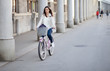 Foto: Young woman riding a bike in the city Young woman riding a bike in the city