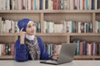 Asian female muslim thinking at library