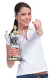 casual woman with trophy points at you