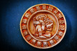 A carved Mayan calendar on textured background