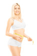 Smiling woman in white cotton underwear measuring her waist