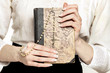 Holy Bible and white rosary in beautiful hands