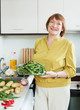 Smiling  woman cooking vegetables with okra