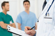 Photo: Doctor Writing On A Clipboard Doctor Writing On A Clipboard