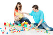 Photo: Happy family. Parents playing with child and toys over white Happy family. Parents playing with child and toys over white