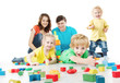 Photo: Happy family. Parents, three kids playing blocks toys Happy family. Parents, three kids playing blocks toys