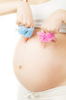 Pregnant belly, newborn baby clothes, boy or girl