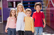 Children Standing Arms Around In Kindergarten