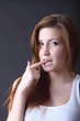 Junge schöne Frau mit Finger im Mund