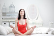 beauty girl in lotus pose indoors