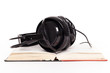 Headphones and book on a white background